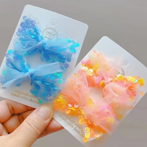 Dettaglio di fermagli per capelli a fiocco con paillettes blu e rosa per bambine
