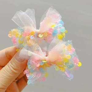 Dettaglio dei fermagli per capelli in rete rosa con paillettes colorate per bambine