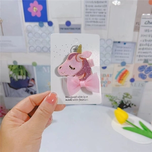 Détail d'une pince à cheveux licorne rose avec paillettes et nœud en tulle souple
