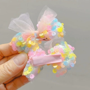 Dettaglio di fermagli per capelli con fiocchi in mesh e paillettes colorate e clip rivestite