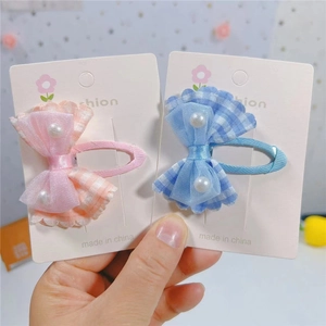 Détail des barrettes nœuds en maille à carreaux avec perles en rose et bleu