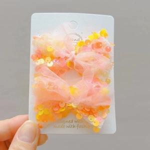 Dettaglio ravvicinato di fermagli per capelli con paillettes fatti a mano in rete arancio