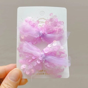 Set di due fiocchi per capelli viola chiaro con paillettes su carta bianca