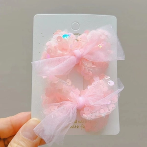 Coppia di fermagli per capelli rosa con fiocchi di paillettes per bambine su cartoncino