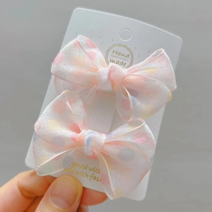 Detail of pink and white polka dot lace bow hair clips set on a handmade display card