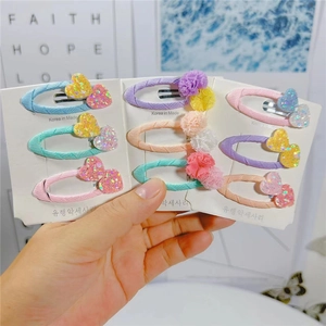 Dettaglio di nove fermagli per capelli colorati per bambini con paillettes e pon-pon