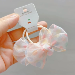 Detailed view of pink polka dot organza bow hair tie with transparent lace texture