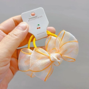 Close-up of a double-layered polka dot tulle bow hair tie on a white display card