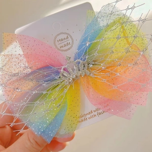 Close-up of rainbow mesh hair bow clip with a rhinestone crown on a handmade card