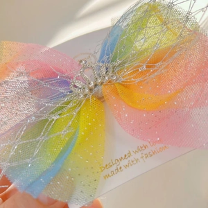 Detail of colorful gradient mesh bow hair clip with a silver rhinestone crown center