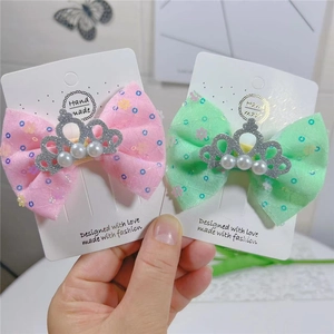 Détails de la couronne pailletée et des perles sur les pinces à cheveux à nœud coloré