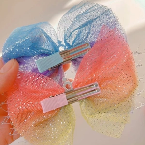 Detail of glittery rainbow mesh bow hair clips with soft color gradient for girls