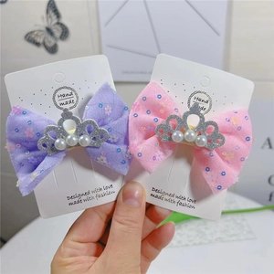 Détail de barrettes à nœuds 9cm aux couleurs acidulées avec couronnes de perles