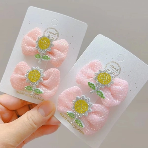 Detailaufnahme rosa Netz-Haarschleifen mit glitzernden Sonnenblumen und Strass-Akzenten