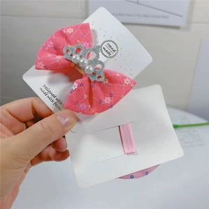 Détail du nœud papillon rose fleuri avec couronne pailletée et perles blanches