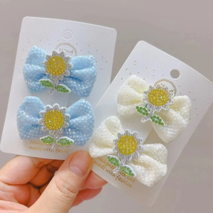 Nahaufnahme von Glitzernetz-Haarschleifen mit Sonnenblumen-Strass auf Displaykarte
