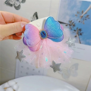 Macro detail of gradient glitter bow hairpin with blue gem and silver star tulle