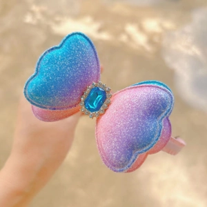 Glittering blue purple gradient butterfly bow headband with centered blue gemstone