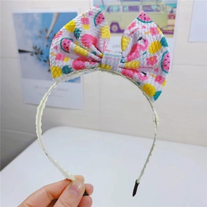 Détail d'un bandeau bohème avec nœud imprimé de flamants roses et fruits d'été