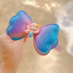 Close-up of glittery gradient butterfly hair clip with mermaid cartoon detail for girls