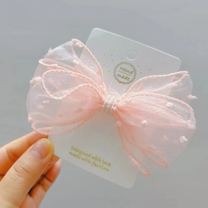 Pink polka dot seersucker bow hair clip for girls on elegant white handmade display card