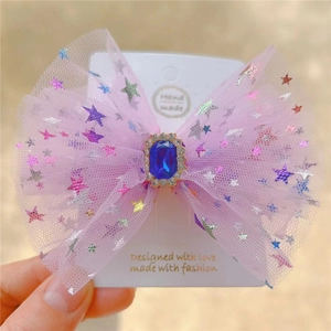 Detail of pink mesh bow hair clip with blue gemstone and glitter stars for girls