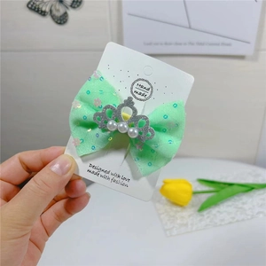 Nœud pour cheveux vert menthe avec couronne argentée et perles sur carte cadeau