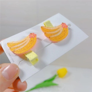 Detail view of cute sequined banana hair clips with pink flowers for little girls