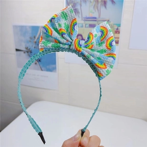 Détail du serre-tête de Pâques avec nœud en tissu gaufré aux motifs arc-en-ciel et trèfle