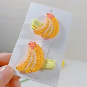 Detail of yellow glitter banana hair clips with pink flowers for kids on display card