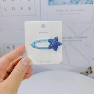 Dettaglio ravvicinato di un fermaglio per capelli a stella blu su una carta di marca