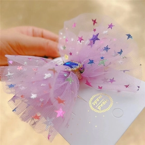 Detailed close-up of a purple mesh hair bow with star patterns and a blue gemstone