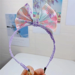 Détail du serre-tête à fleurs avec un grand nœud en tissu gaufré violet et doux