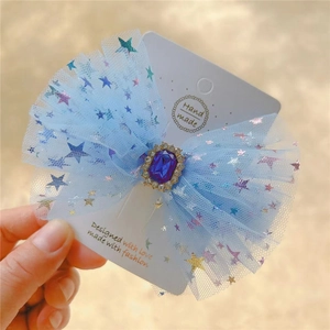 Macro view of blue mesh bow hair clip with sapphire center and glitter star details