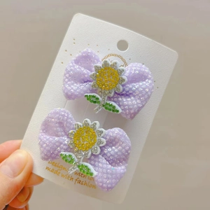 Detail von zwei lila Tüll-Haarspangen mit glitzernden Sonnenblumen-Diamantakzenten