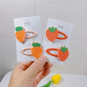 Detail shot of cute carrot and strawberry felt hair clips on display cards for kids