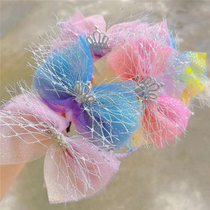 Close-up of colorful gradient tulle bow headband with silver crown detail for girls
