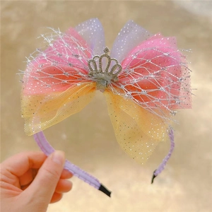 Close-up of glittery mesh bow headband with a sparkling silver crown for girls