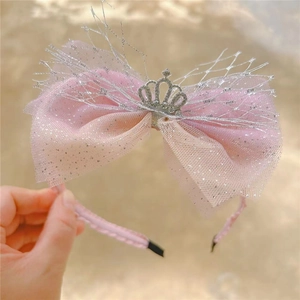 Close-up of pink mesh bow headband with silver crown and glitter for girls