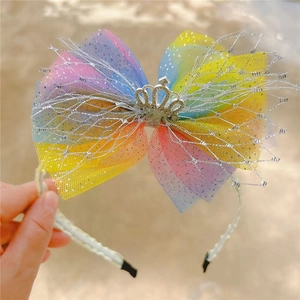 Close-up of rainbow mesh bow headband featuring a silver crown and sparkling rhinestones