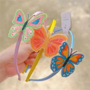 Detailed view of glittery butterfly headbands for girls in pink, yellow, and blue colors