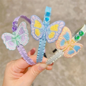 Close-up of three butterfly embroidered headbands with heart rhinestones and ribbon wrap