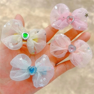 Détail de quatre barrettes en tulle avec strass en forme de cœur et perles pour enfants
