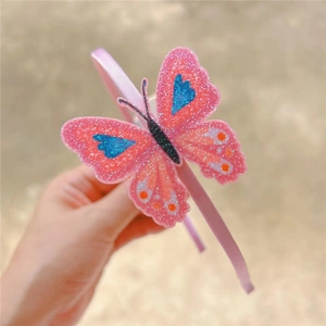 Close-up of a pink glitter butterfly headband with heart patterns for young girls