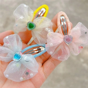 Détail de barrettes en tulle pour enfants avec cœurs brillants et petites étoiles blanches