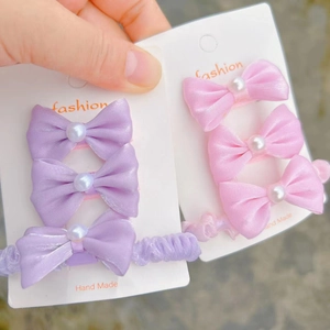 Detail of 3-piece hair accessory set with elegant satin bows and pearls for girls