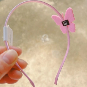 Detailed close-up of a pink glitter butterfly headband for girls with a small crown emblem