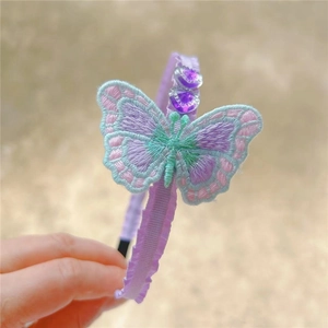 Detail of a purple butterfly embroidery headband with beads and ruffled ribbon