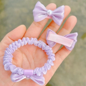 Detailed view of lavender satin bow hair tie with pearl and matching clips set