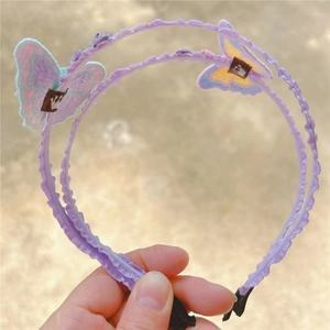 Detailed view of embroidery butterfly and crown label on double-layered purple headband